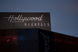 Hollywood Megaplex sign illuminated against a dark blue evening sky.