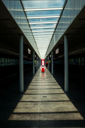 Long symmetrical corridor with skylight ceiling creating dramatic shadows and light patterns.