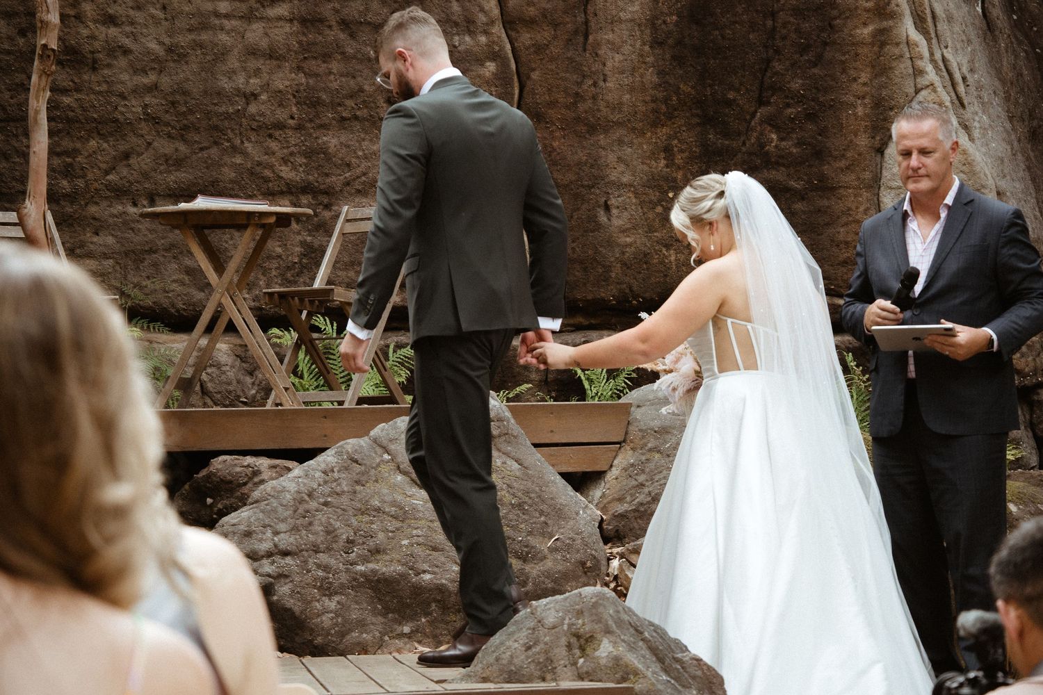 An intimate outdoor wedding ceremony takes place among dramatic rock formations.