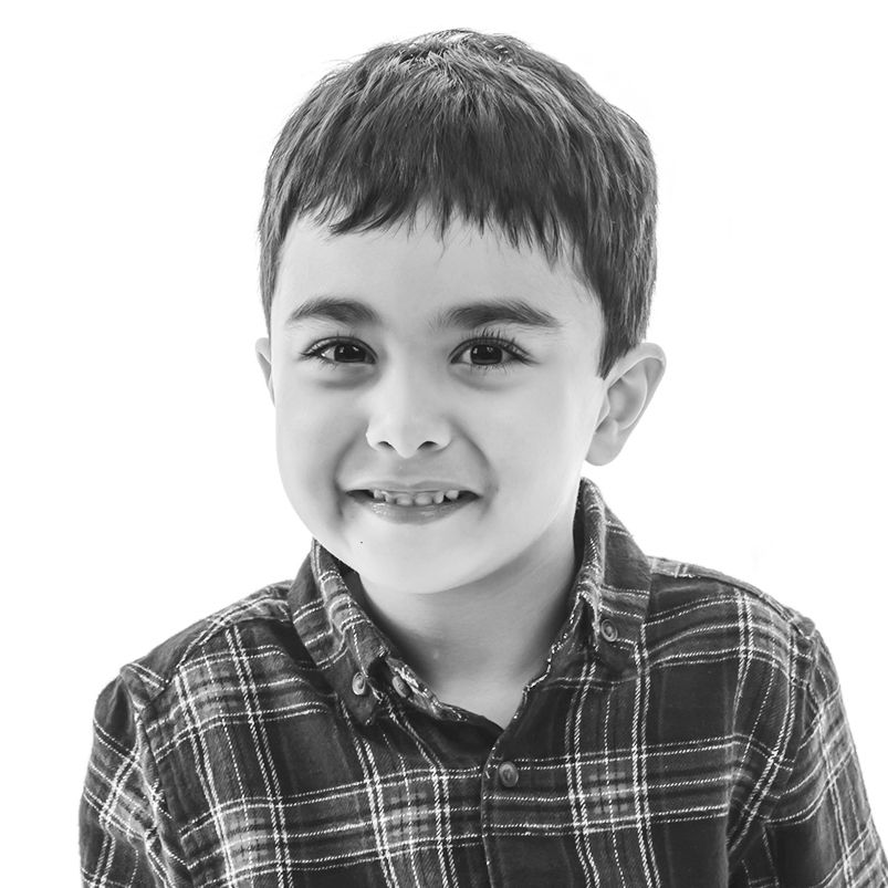 Photo of a young boy showing an option in black and white. A school studio photo taken on a white background.