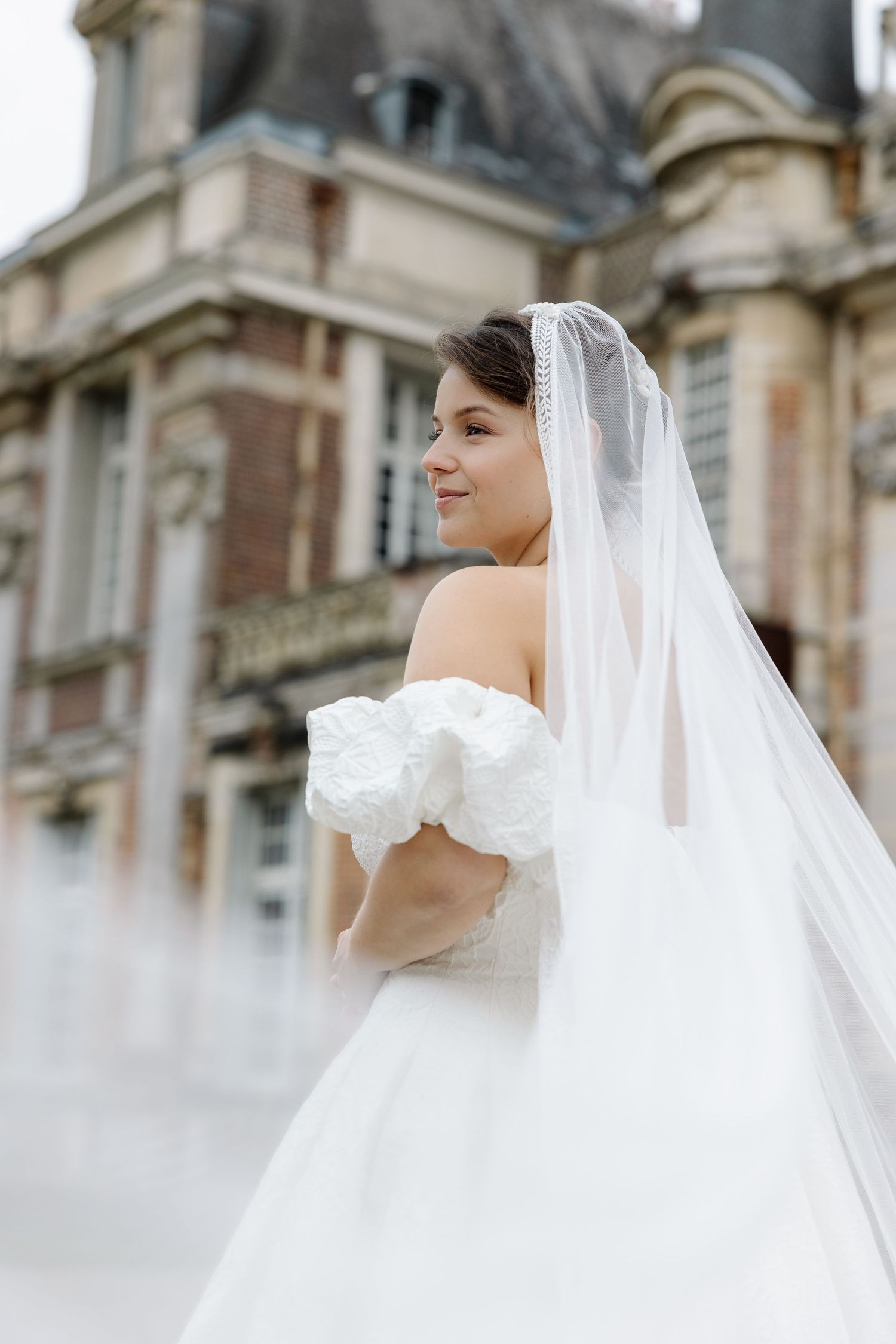 Ethereal bridal portraits featuring flowing veil against classic architecture.