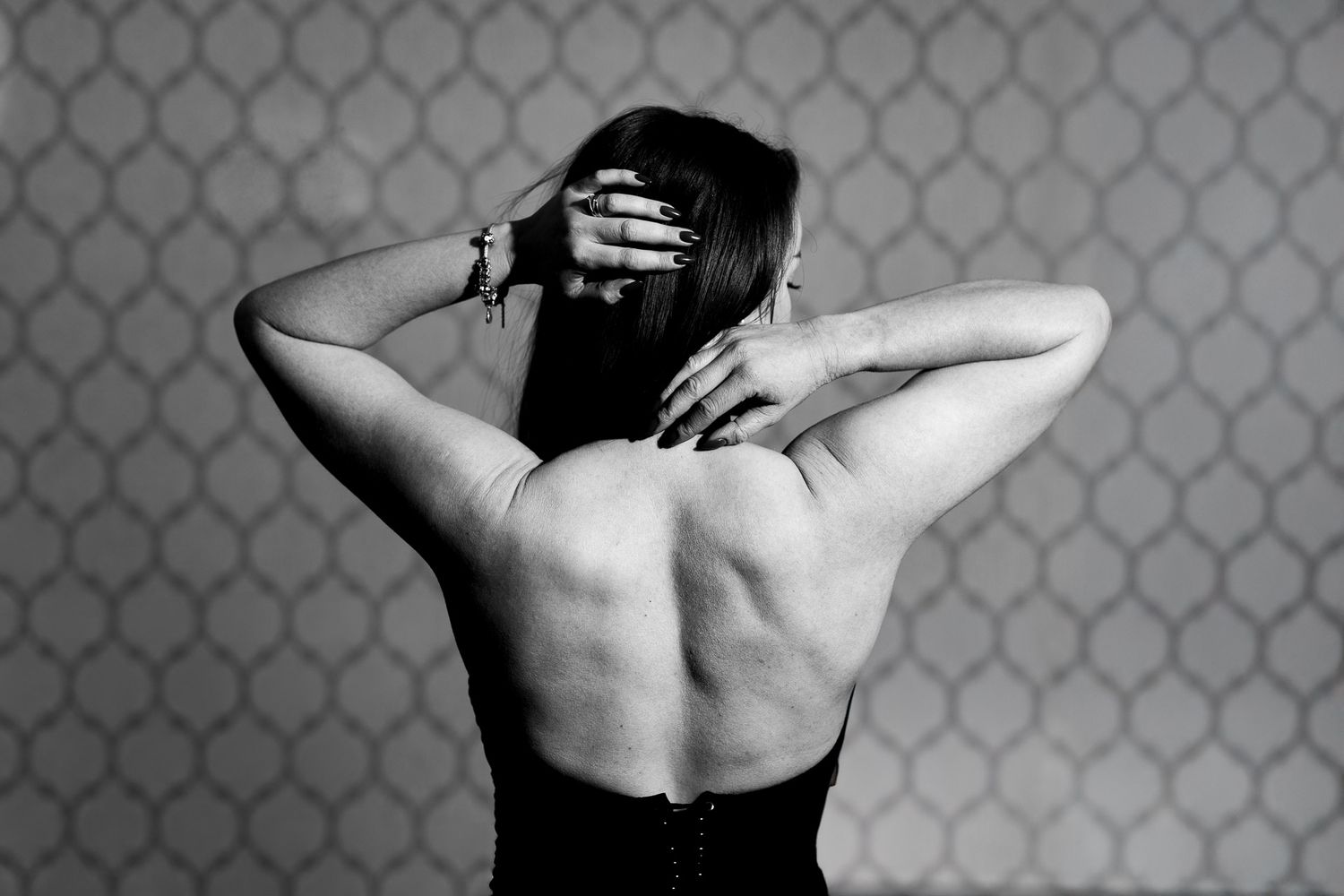 Black and white photo series showing a person with hands clasped behind their neck in different dramatic poses.