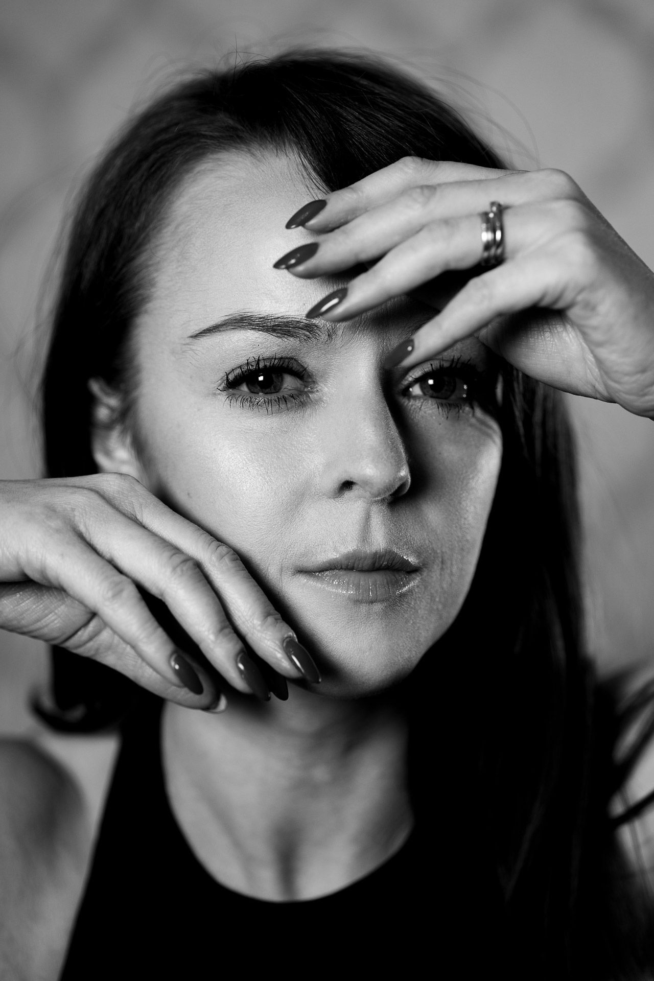 A series of black and white portraits showing hands gracefully framing the face in different dramatic poses.