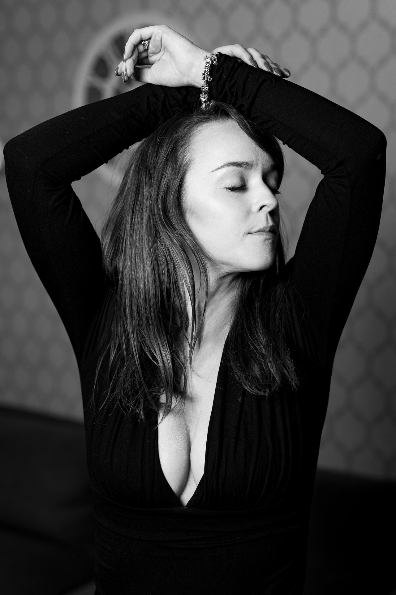 Artistic black and white portrait series showing expressive poses in a dark top against patterned background.