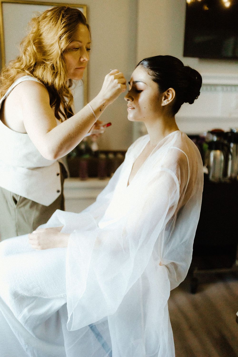 Soft focus shots of someone getting ready in flowing white fabric.