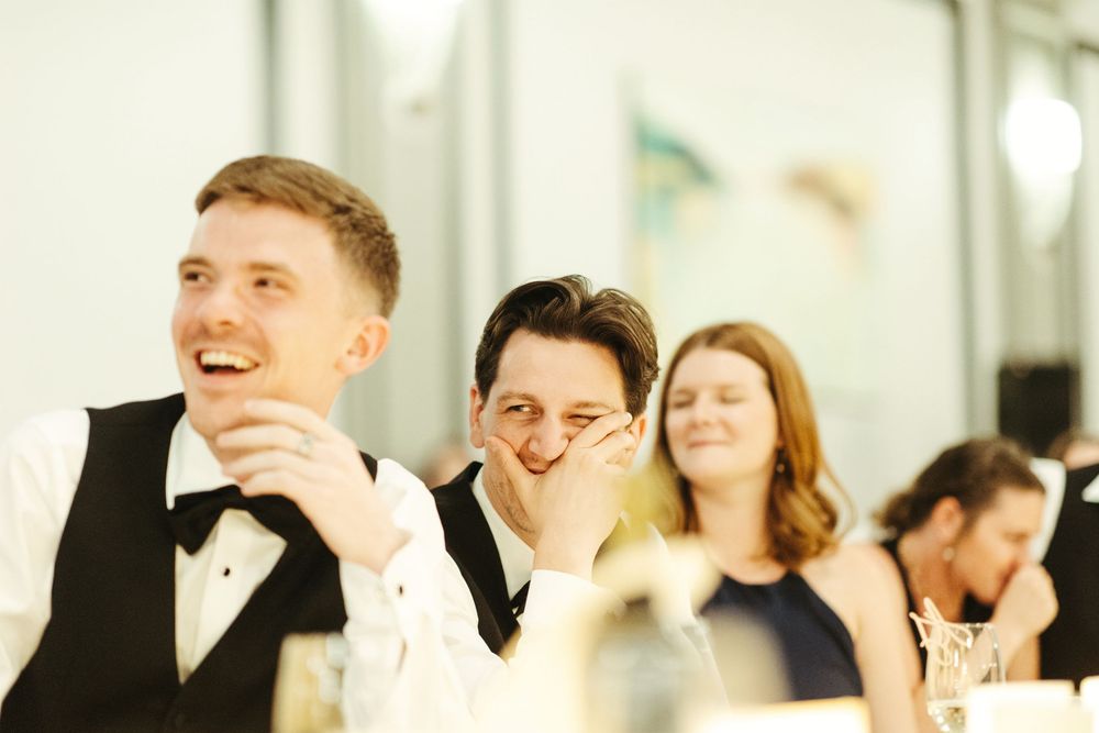 Wedding guests sharing joyful moments during reception celebrations in formal attire.