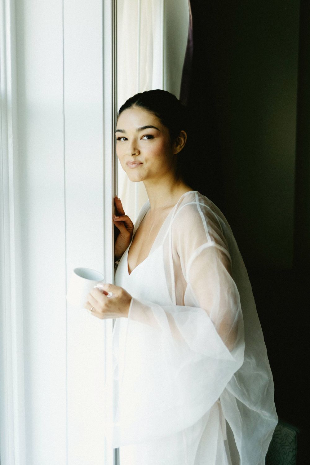 Artistic window-lit portraits showing movement in flowing white fabric.