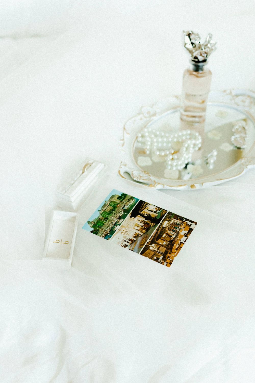 Crystal glassware and vintage photographs arranged on white linen tablecloth.