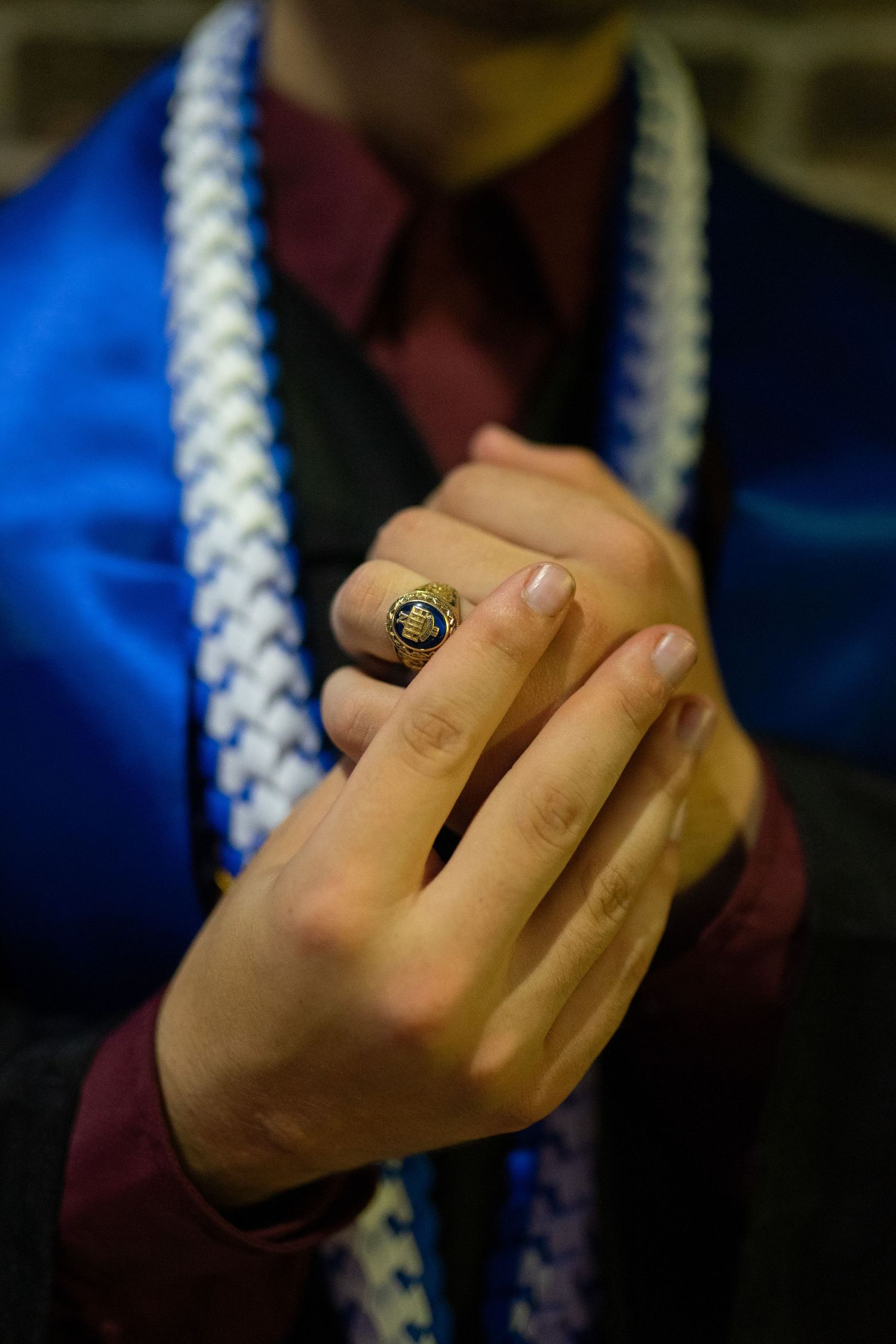 Senior session with senior adjusting graduation ring during relaxed and flexible senior session.