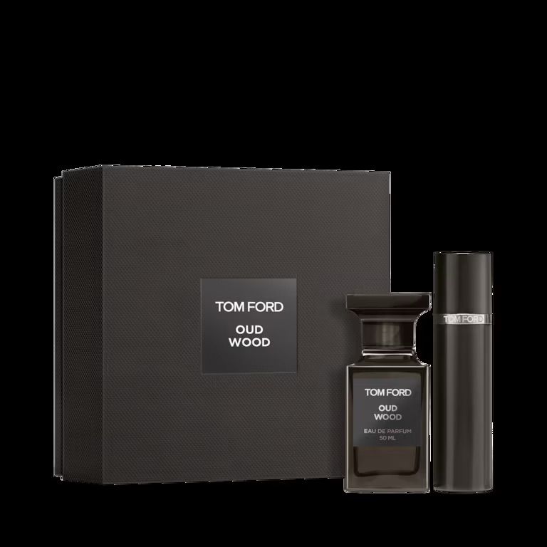 Black luxury fragrance gift set with Tom Ford Oud Wood perfume bottle and matching candle in elegant packaging.