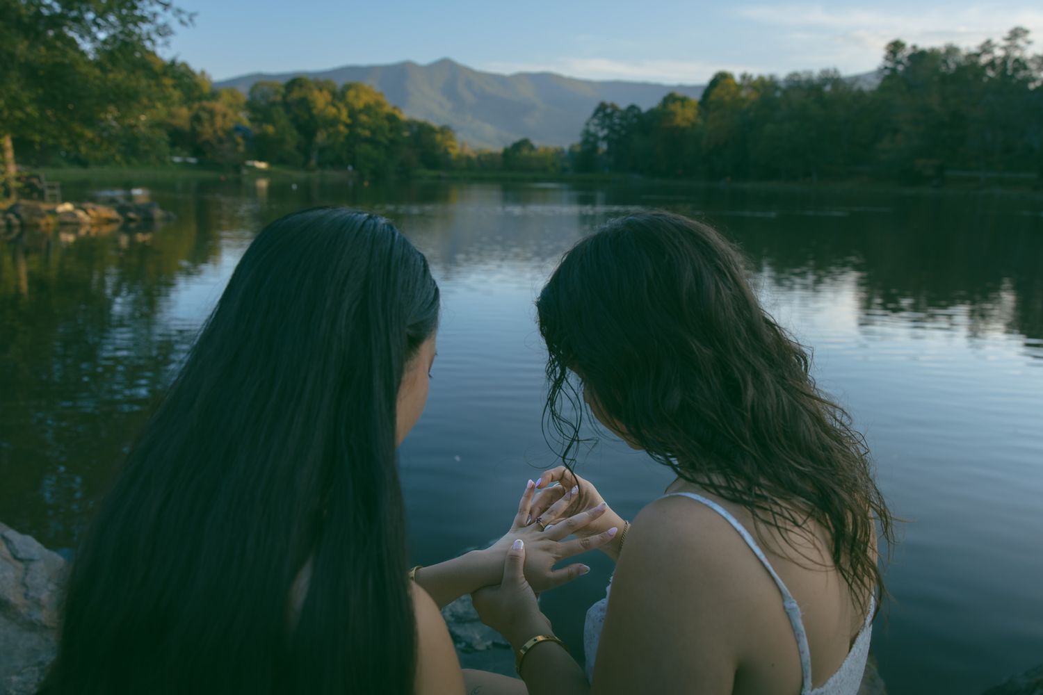 LGBTQ couple holding hands after romantic proposal at blue ridge mountain overlook near Asheville, North Carolina