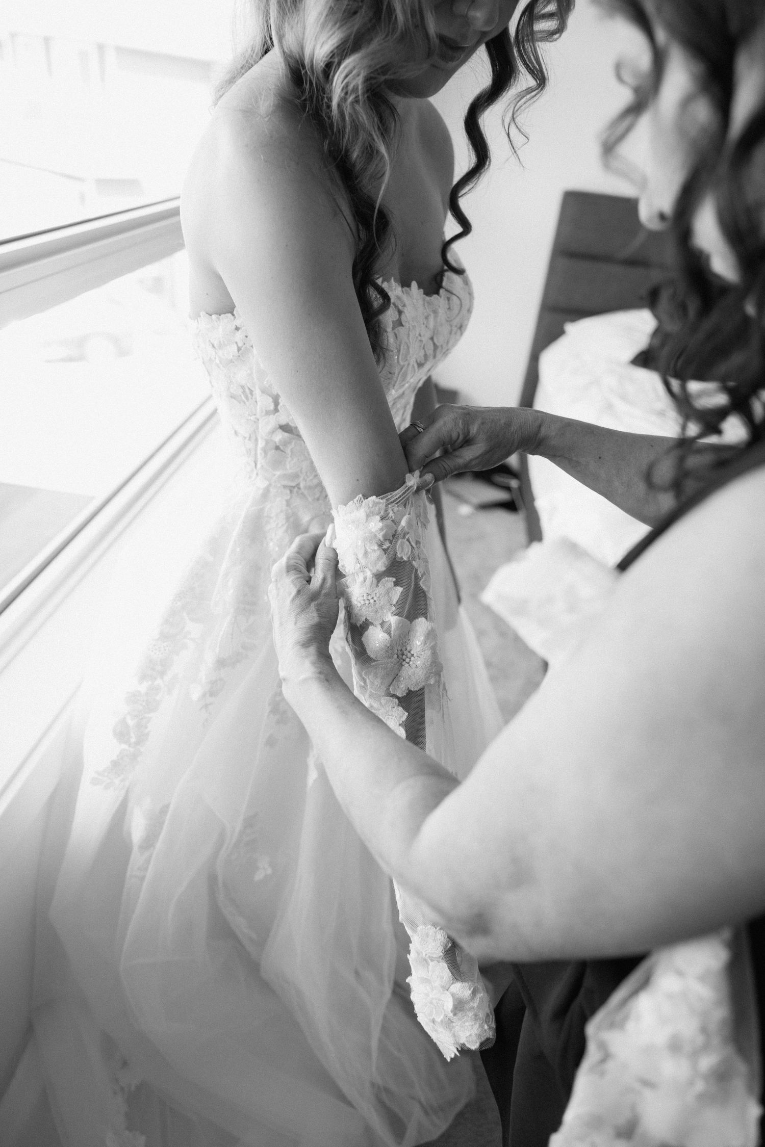 A series of black and white close-up shots showing delicate lace details on a wedding dress.