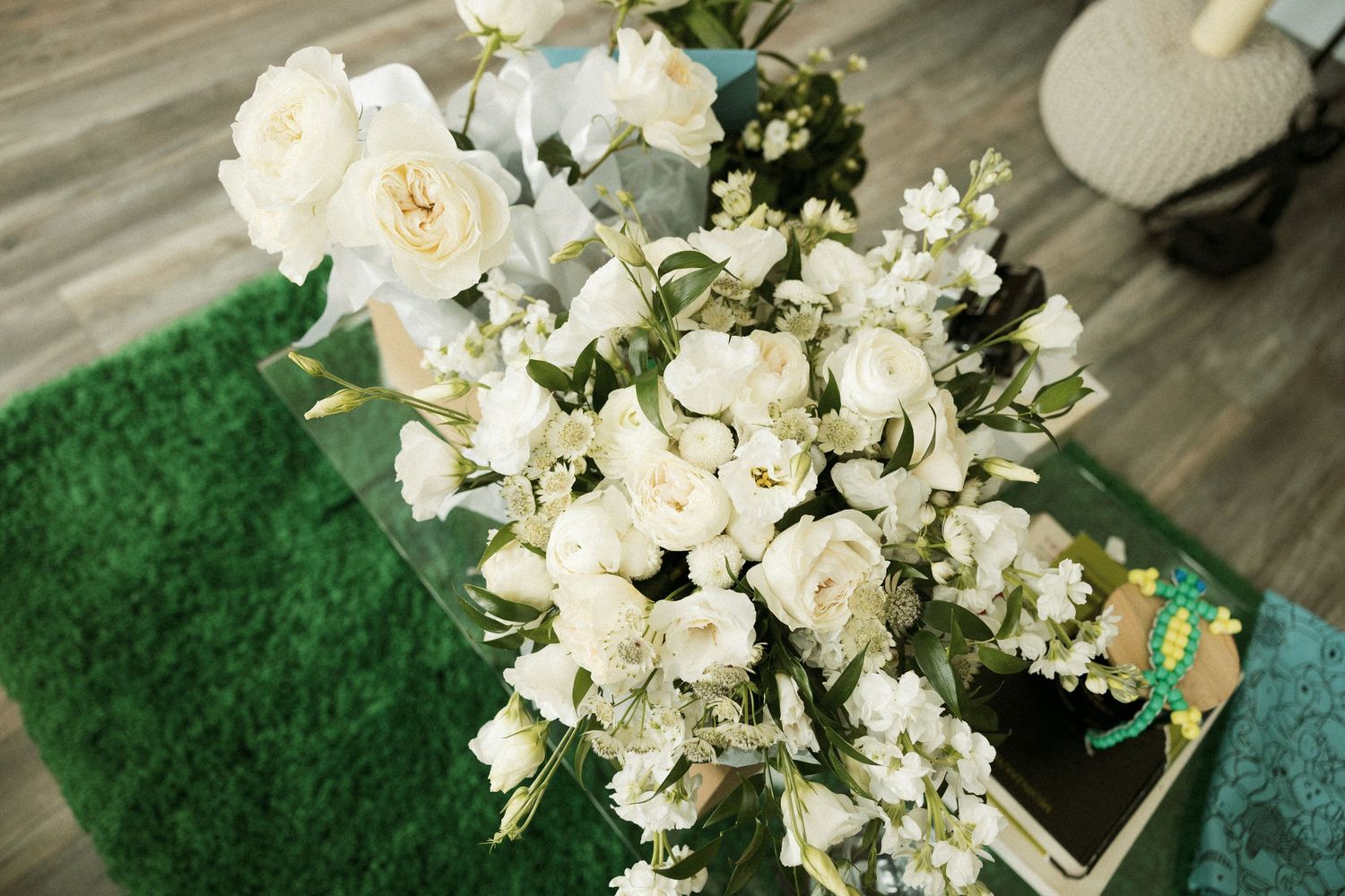 Elegant white and cream floral arrangement with roses and orchids on display.