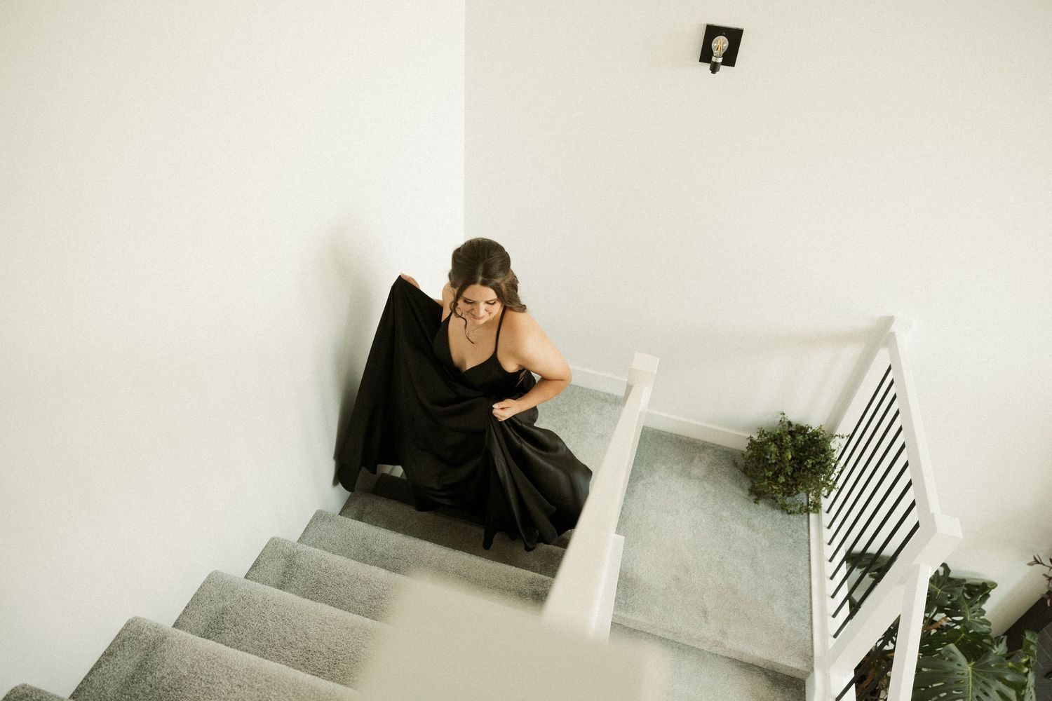 Black and white sequence of figures descending modern white staircase.