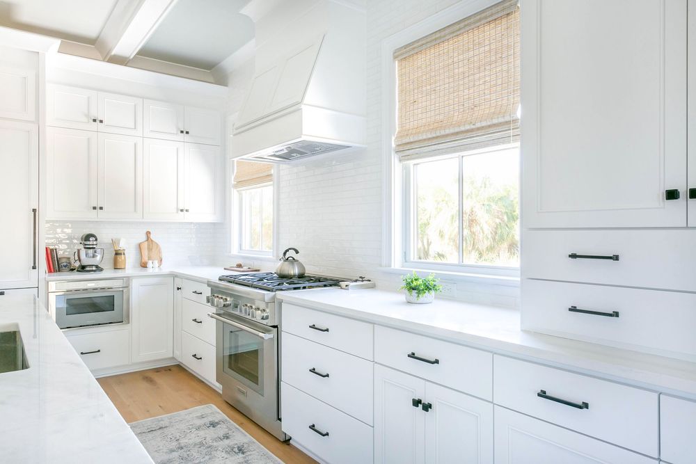 Bright white modern kitchen with natural light and bamboo window shades.