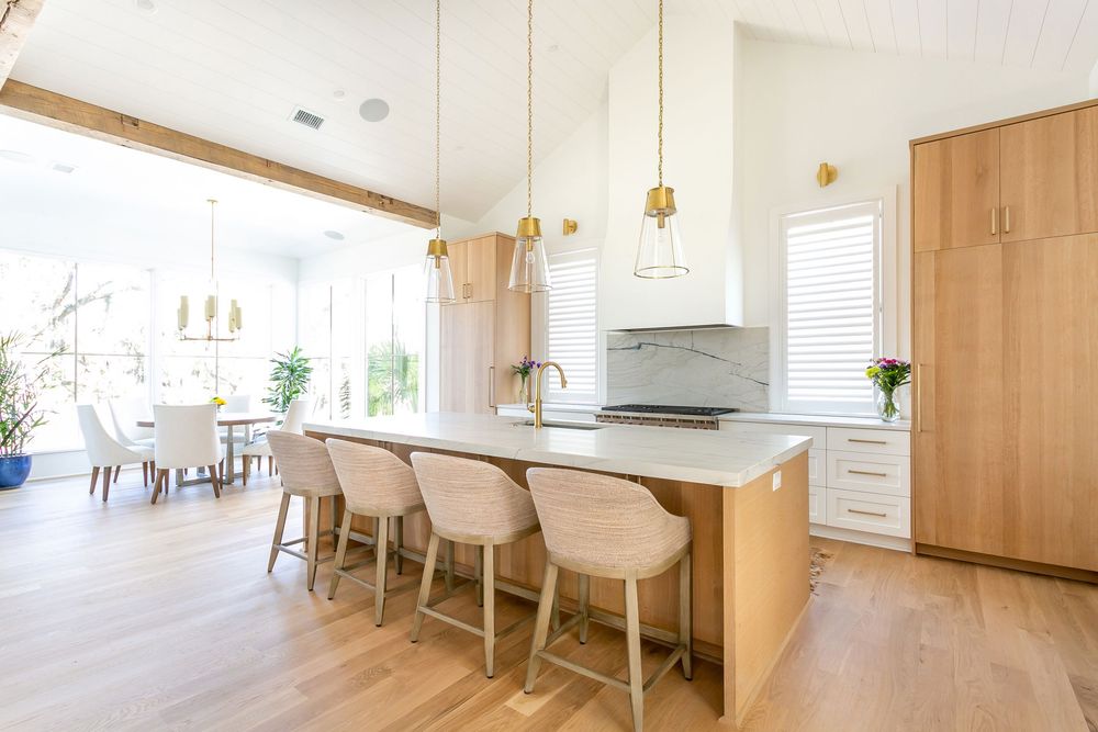 Light-filled modern dining space with white walls and wooden flooring.