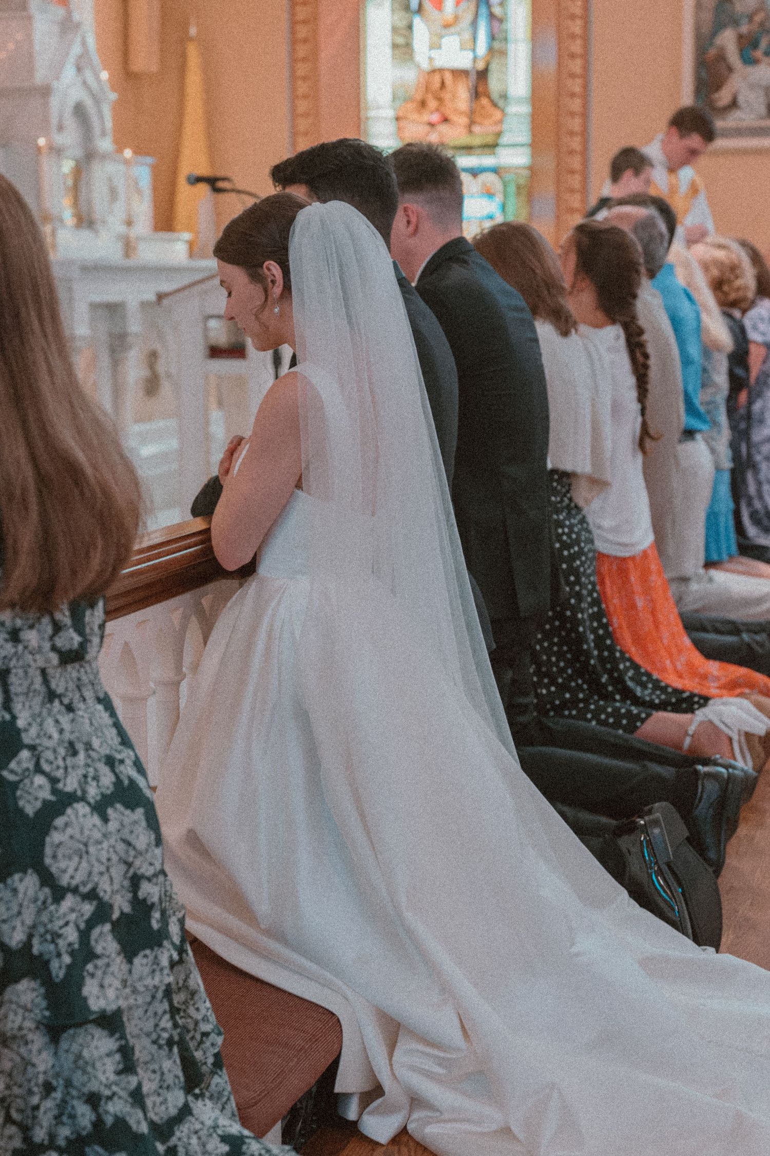 Bride and groom exchanging vows and first kiss at St. Francis of Assisi Church, Staunton, VA, emotional, documentary-style wedding photo.