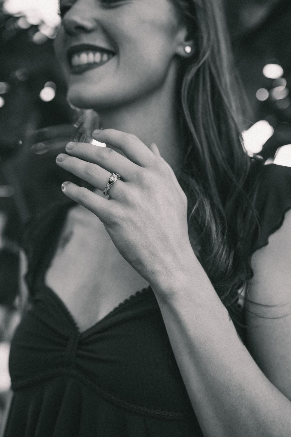 Close-up shot of hands displaying an engagement ring with a joyful expression.