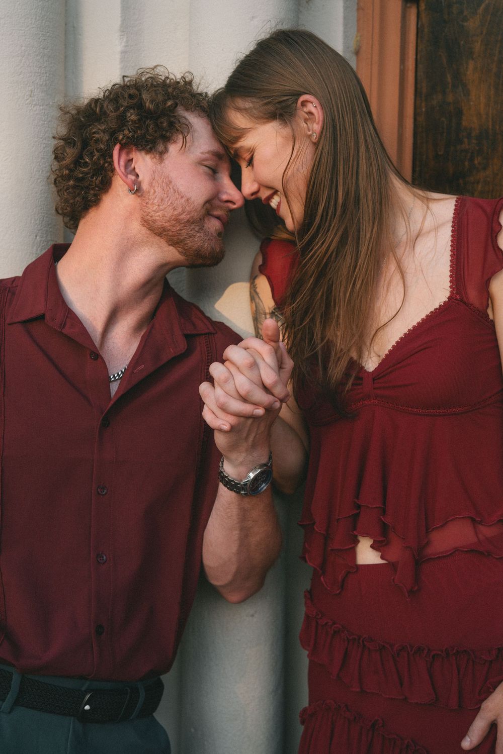 An intimate photo sequence showing tender moments between a couple in burgundy attire.