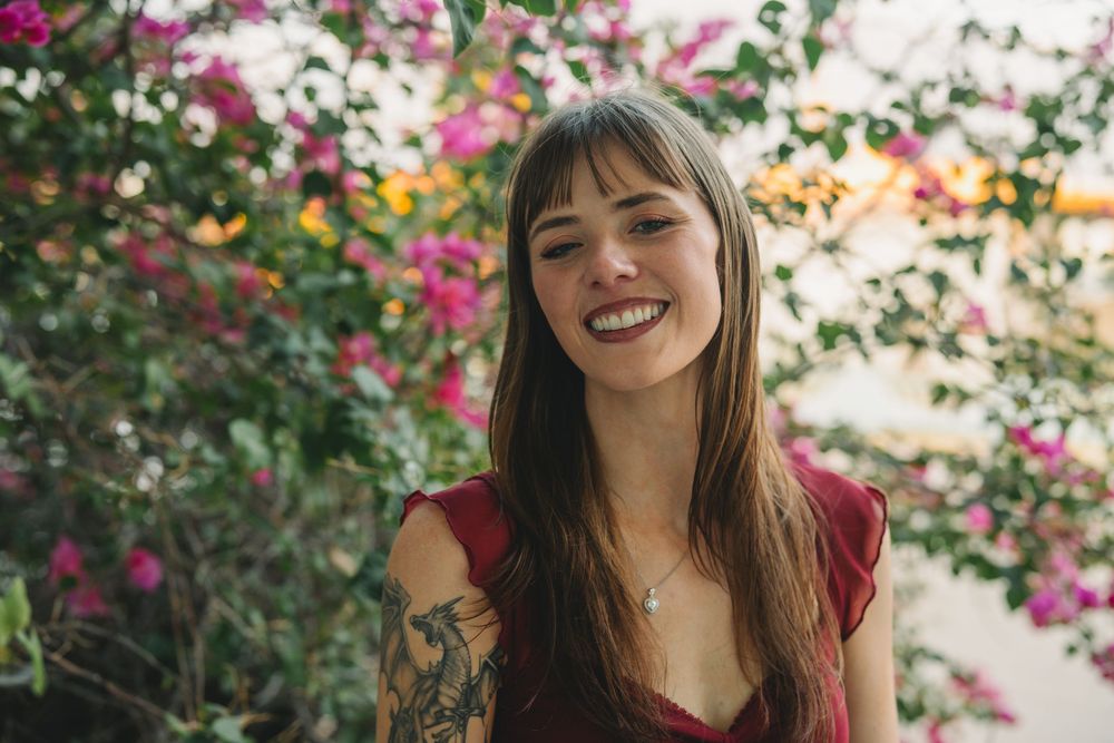 Portrait shots in a garden setting with pink flowers and natural lighting.