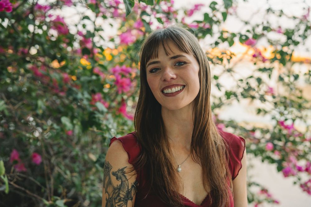 Outdoor portraits captured against a backdrop of colorful flowering bushes.
