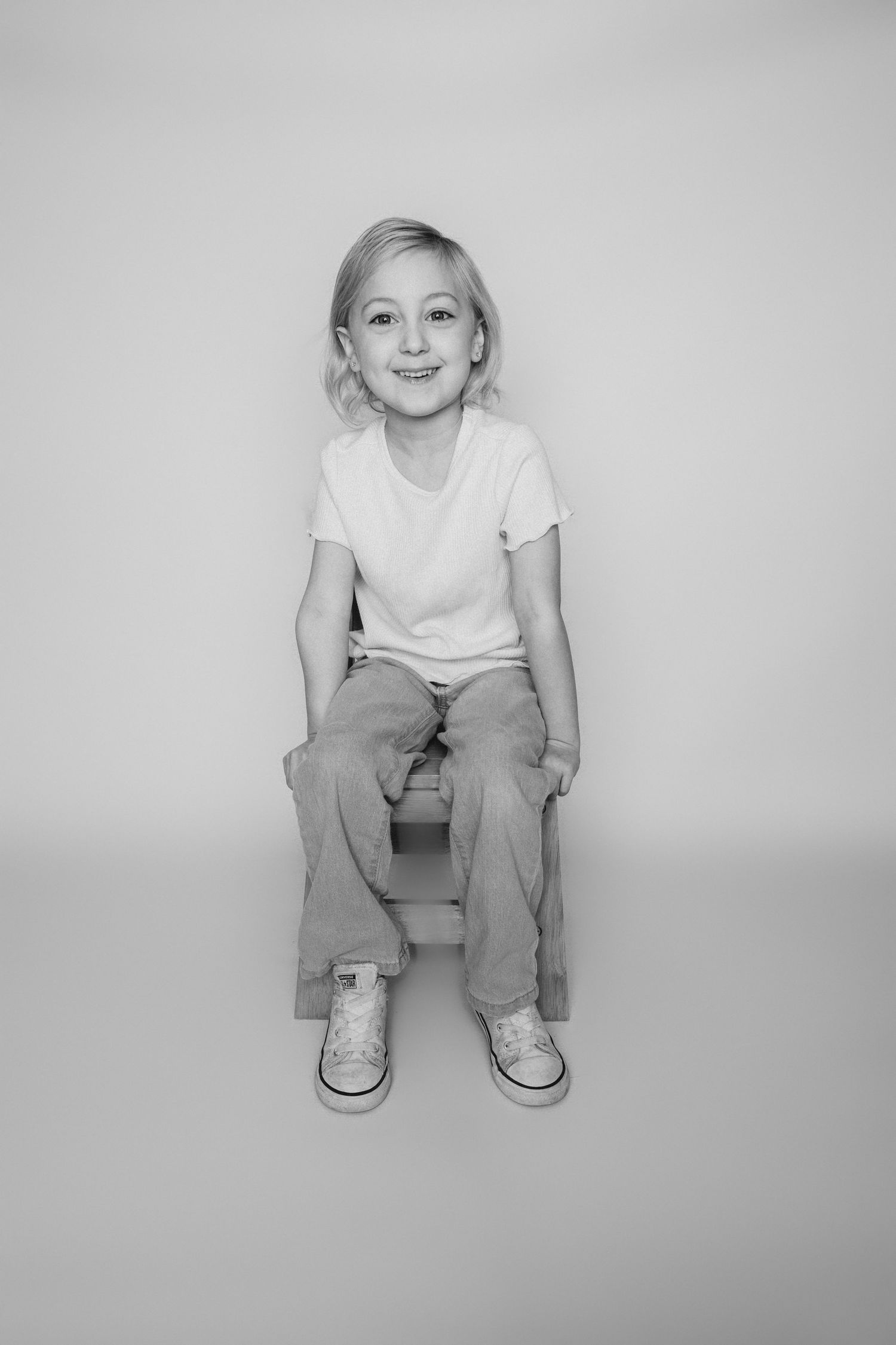 Child sitting in front of a clean white backdrop during an at-home personality portrait session in Marlton, NJ.