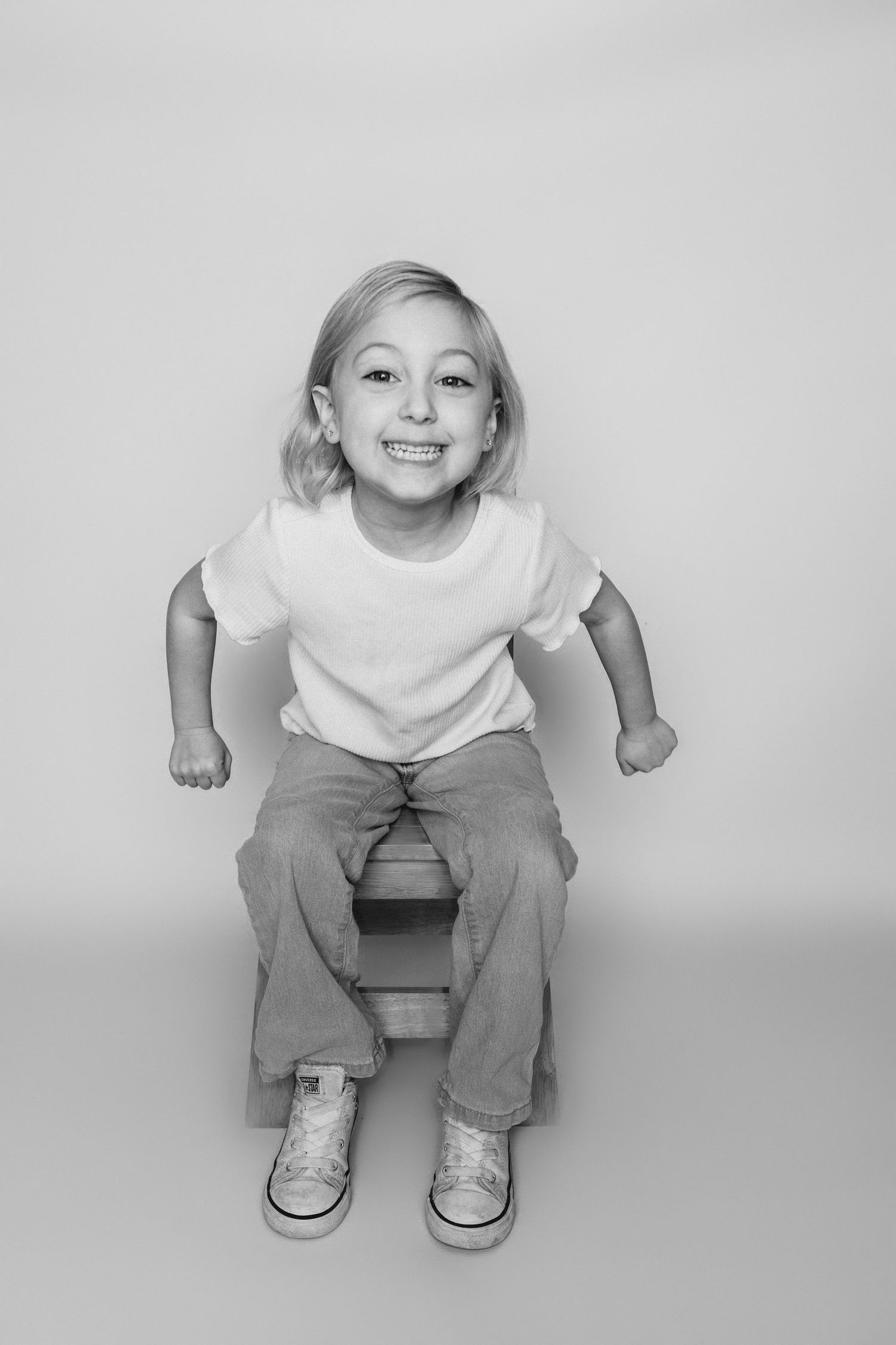 Child sitting in front of a clean white backdrop during an at-home personality portrait session in Marlton, NJ.
