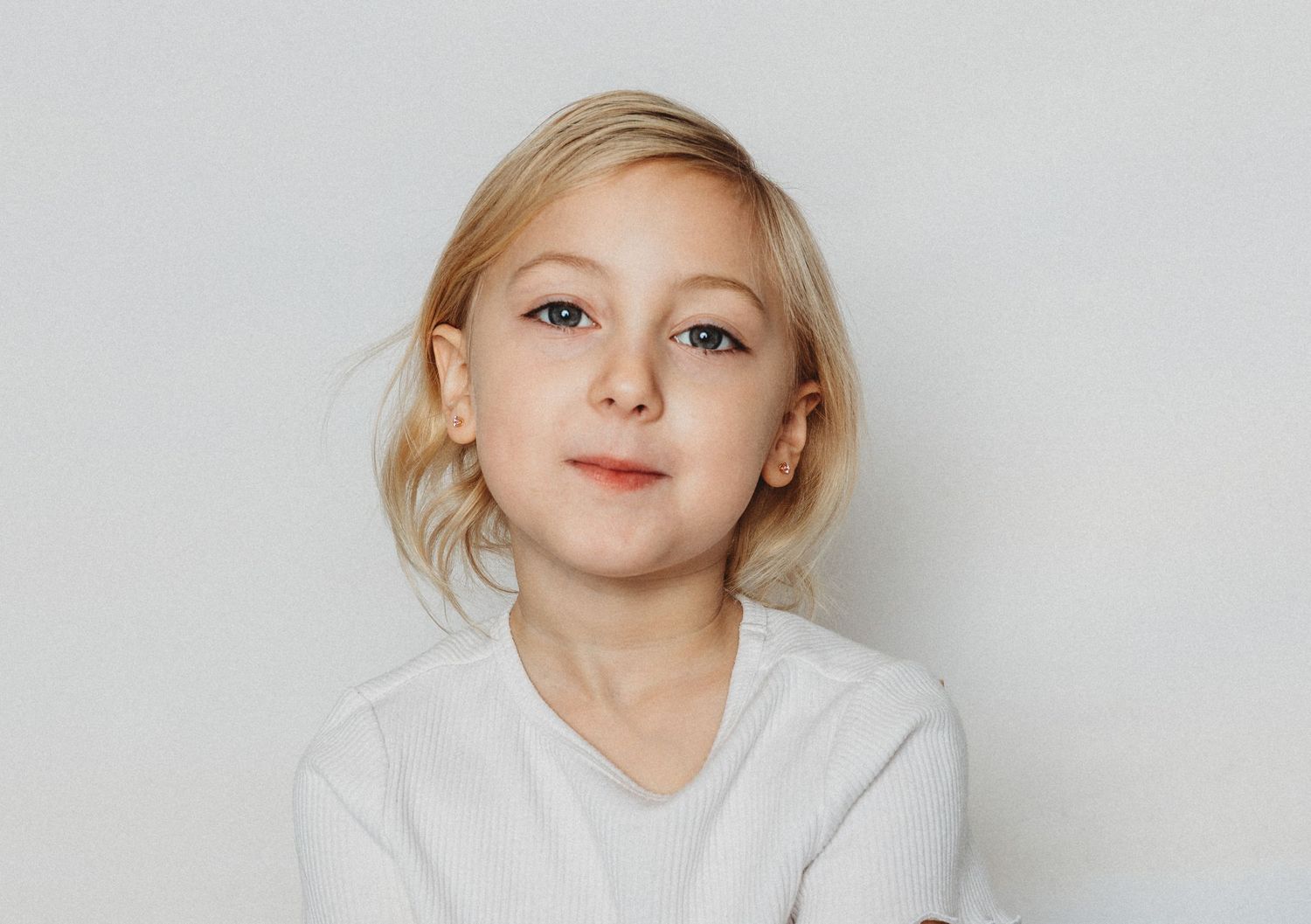 Child sitting in front of a clean white backdrop during an at-home personality portrait session in Marlton, NJ.