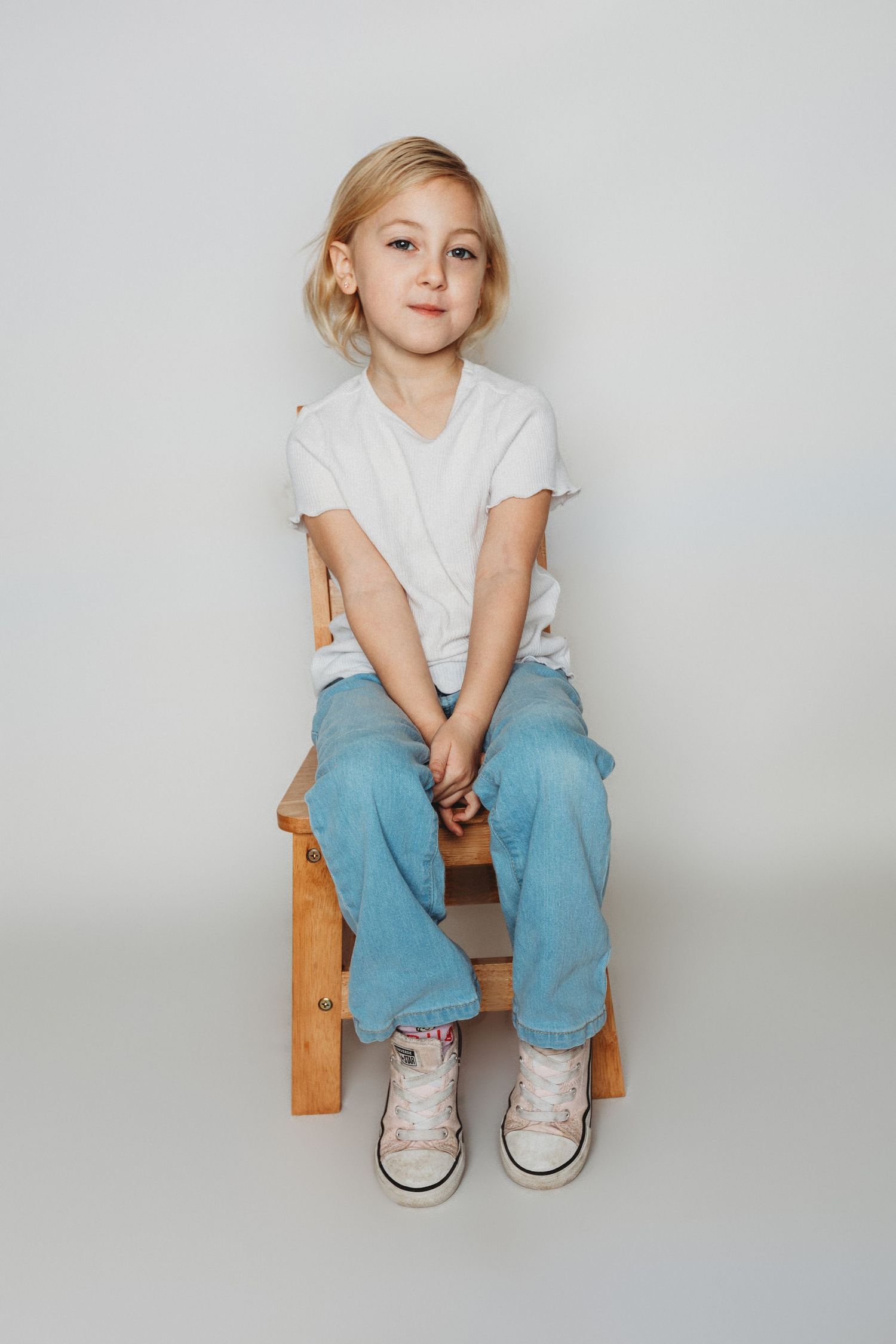 Child sitting in front of a clean white backdrop during an at-home personality portrait session in Marlton, NJ.