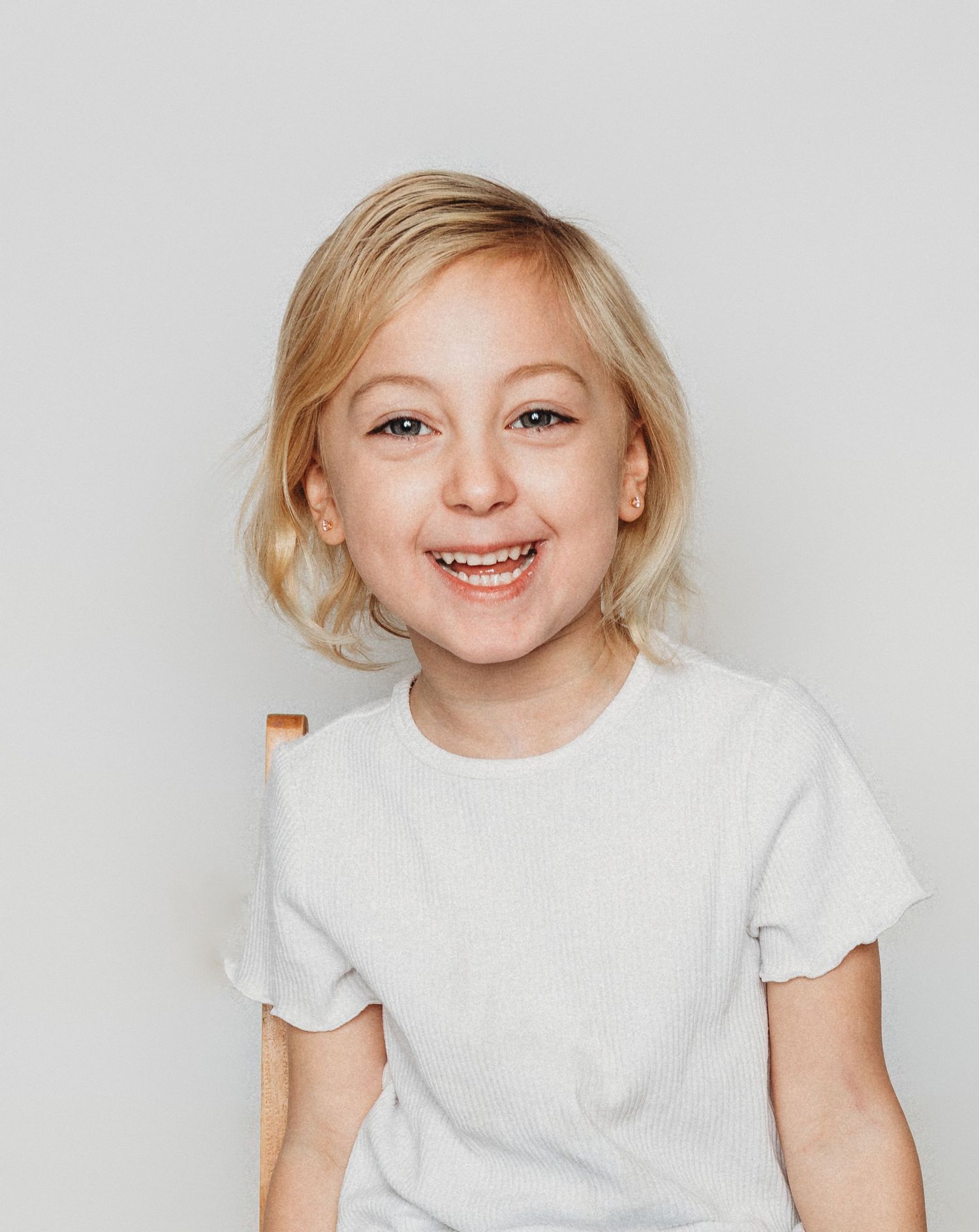 Child sitting in front of a clean white backdrop during an at-home personality portrait session in Marlton, NJ.