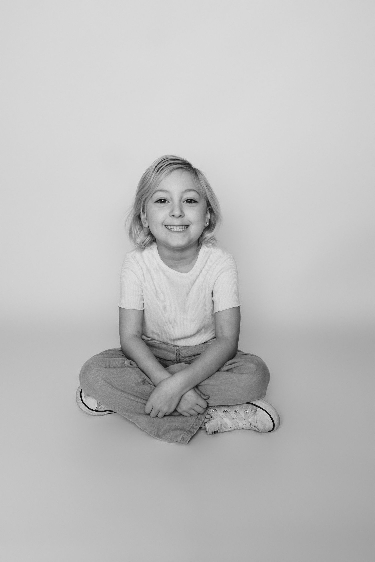 Child sitting in front of a clean white backdrop during an at-home personality portrait session in Marlton, NJ.