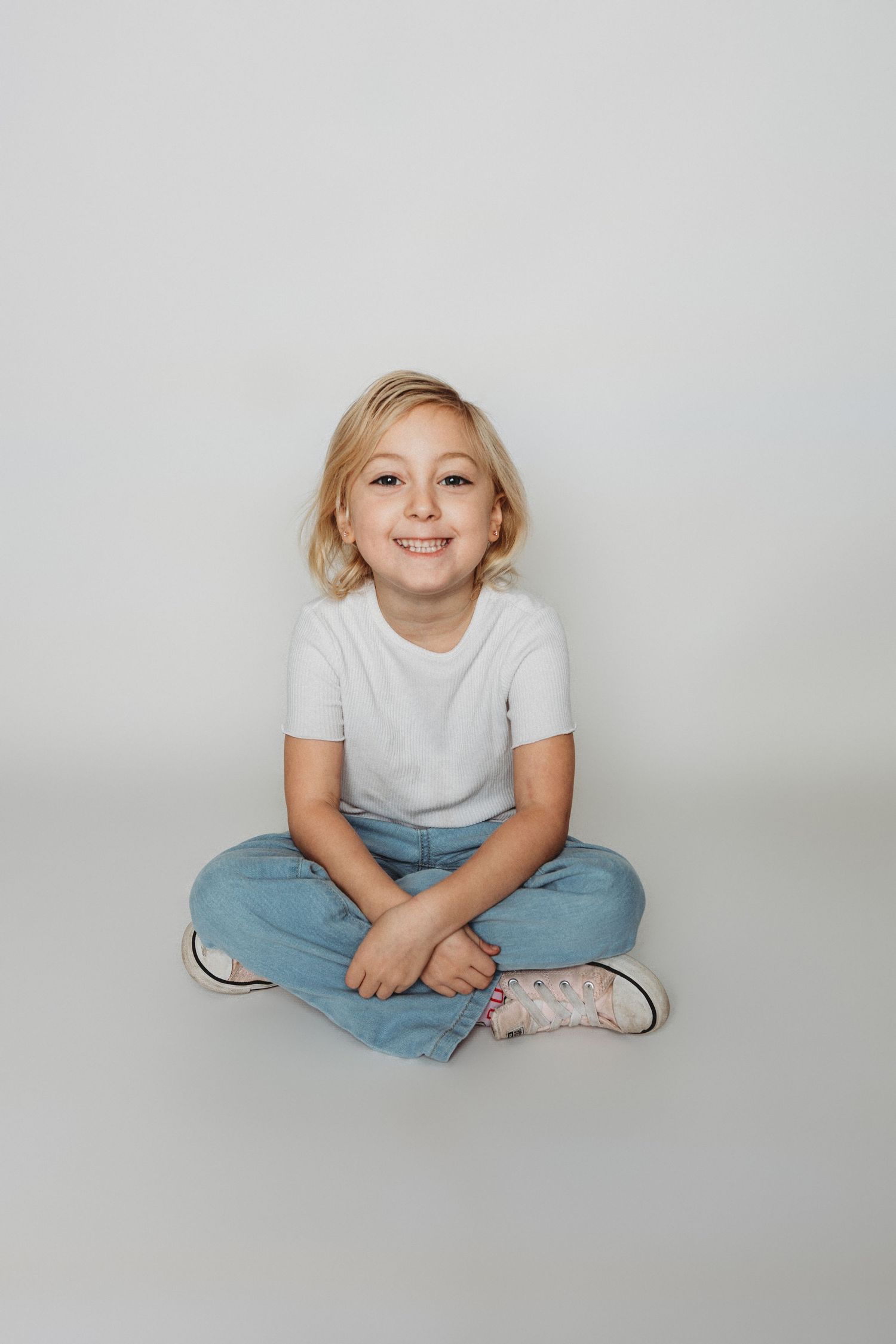Child sitting in front of a clean white backdrop during an at-home personality portrait session in Marlton, NJ.