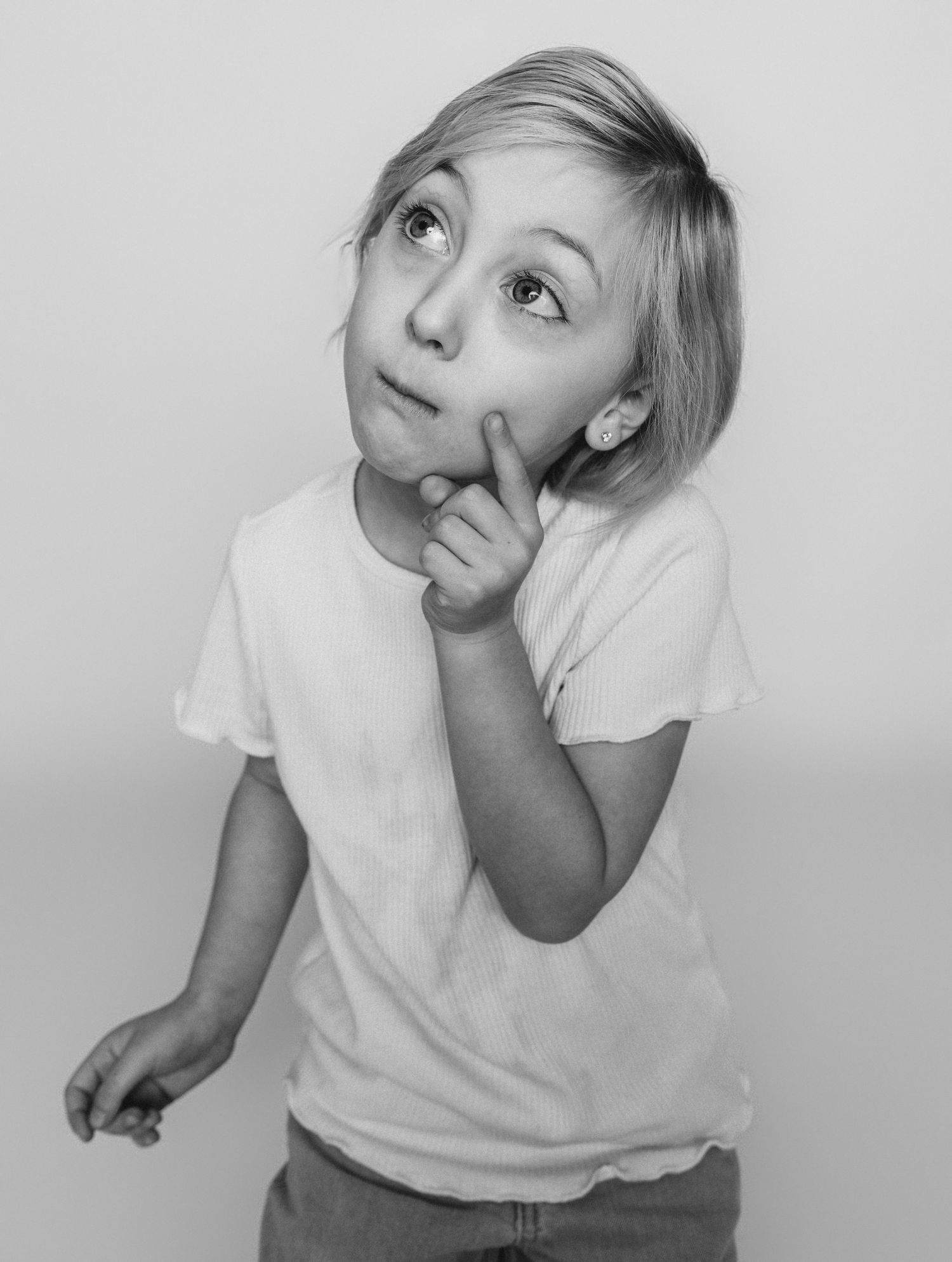 Child sitting in front of a clean white backdrop during an at-home personality portrait session in Marlton, NJ.