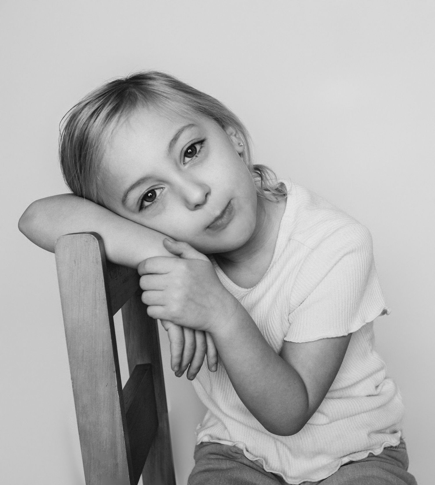 Child sitting in front of a clean white backdrop during an at-home personality portrait session in Marlton, NJ.