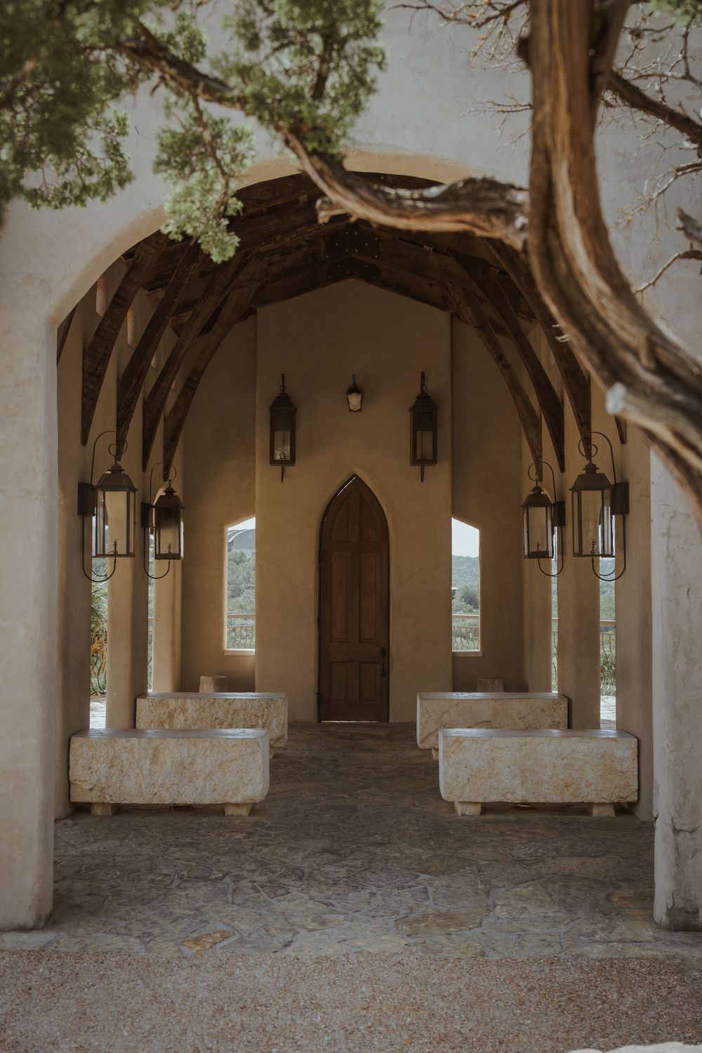 Stone colonnade with arched walkway and hanging lanterns creates dramatic shadows.