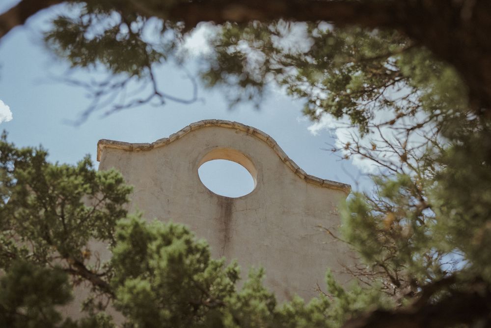 Mission-style architecture detail with curved archways and trees framing the view.