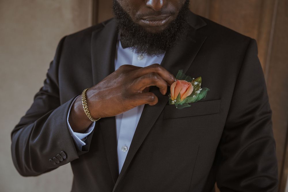 Close-up of formal black suit jacket with boutonniere detail.