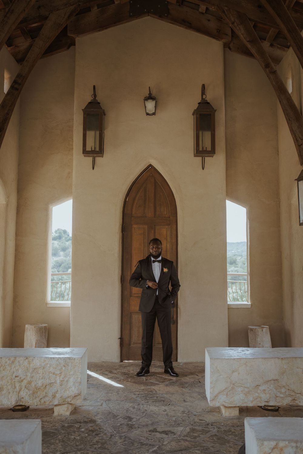 Elegant chapel interior with vaulted ceilings, hanging lanterns, and arched windows casting natural light.
