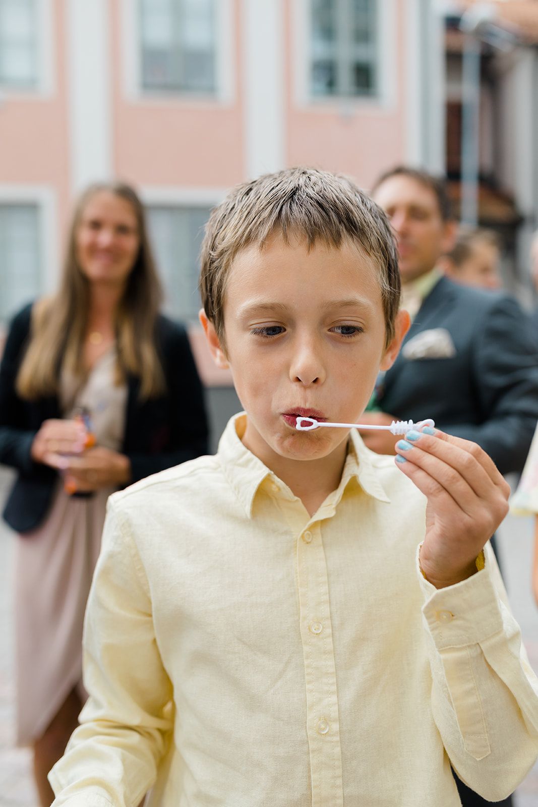A sequence of photos showing a child in a yellow shirt blowing bubbles with a bubble wand.