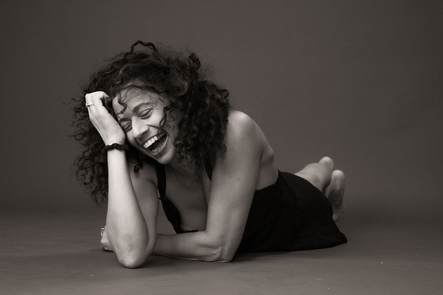 Artistic black and white photo series showing a figure in expressive poses against a dark background.