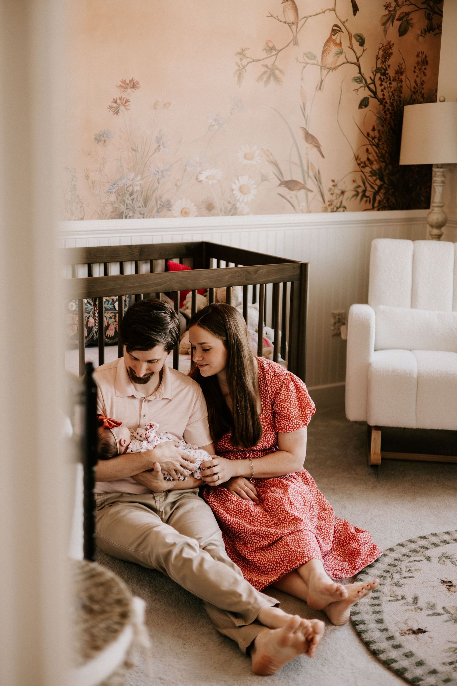 Two people sit together on a cozy gray carpet while reading and sharing a quiet moment in a light-filled room.