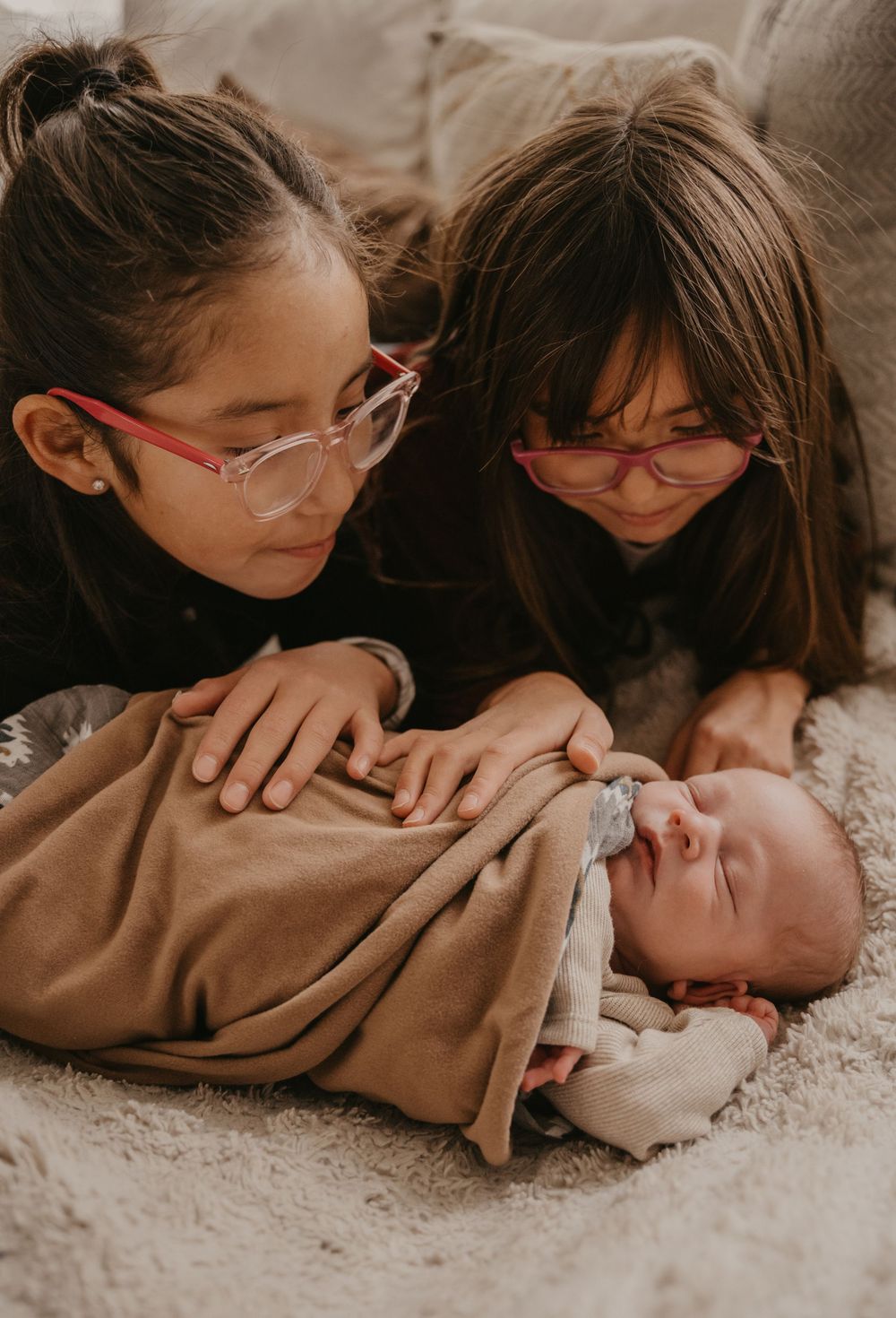A series of intimate photos showing tender moments with a sleeping newborn baby on soft carpet.