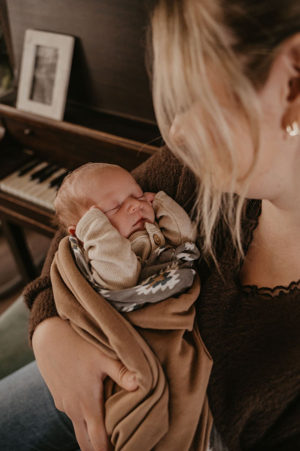A sequence of warm-toned photos showing gentle interactions with a sleeping infant in cozy lighting.