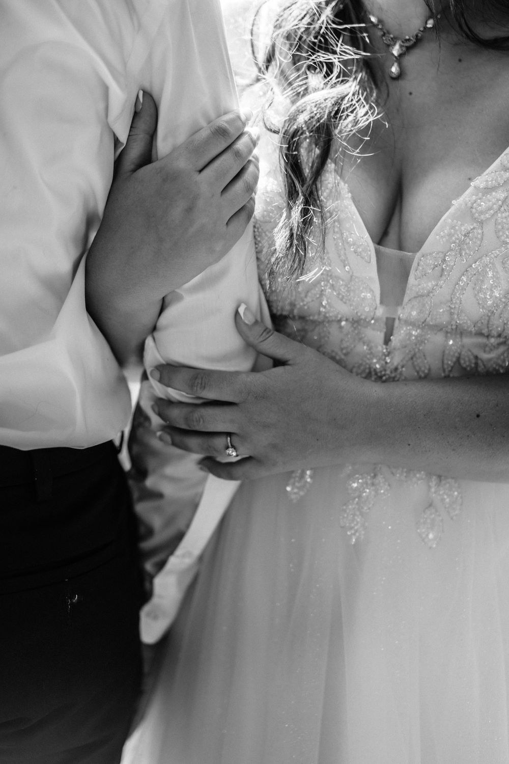 Close-up black and white detail shots of wedding dress and embraces.