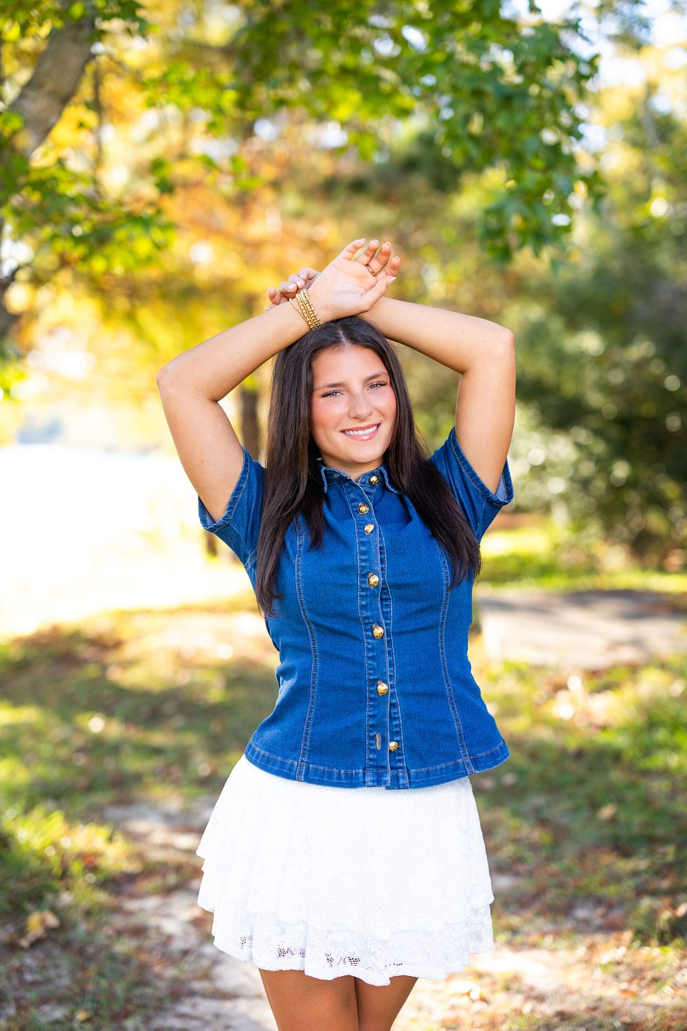 Playful outdoor portrait session featuring a denim and white outfit combination.