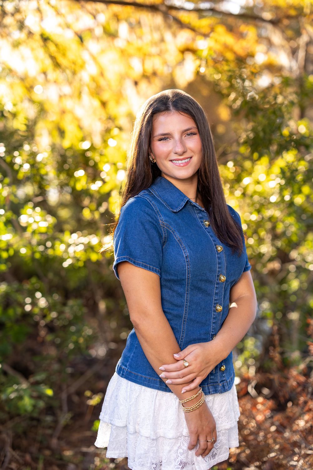 Casual summer fashion shoot with denim and white lace against golden sunlit trees.