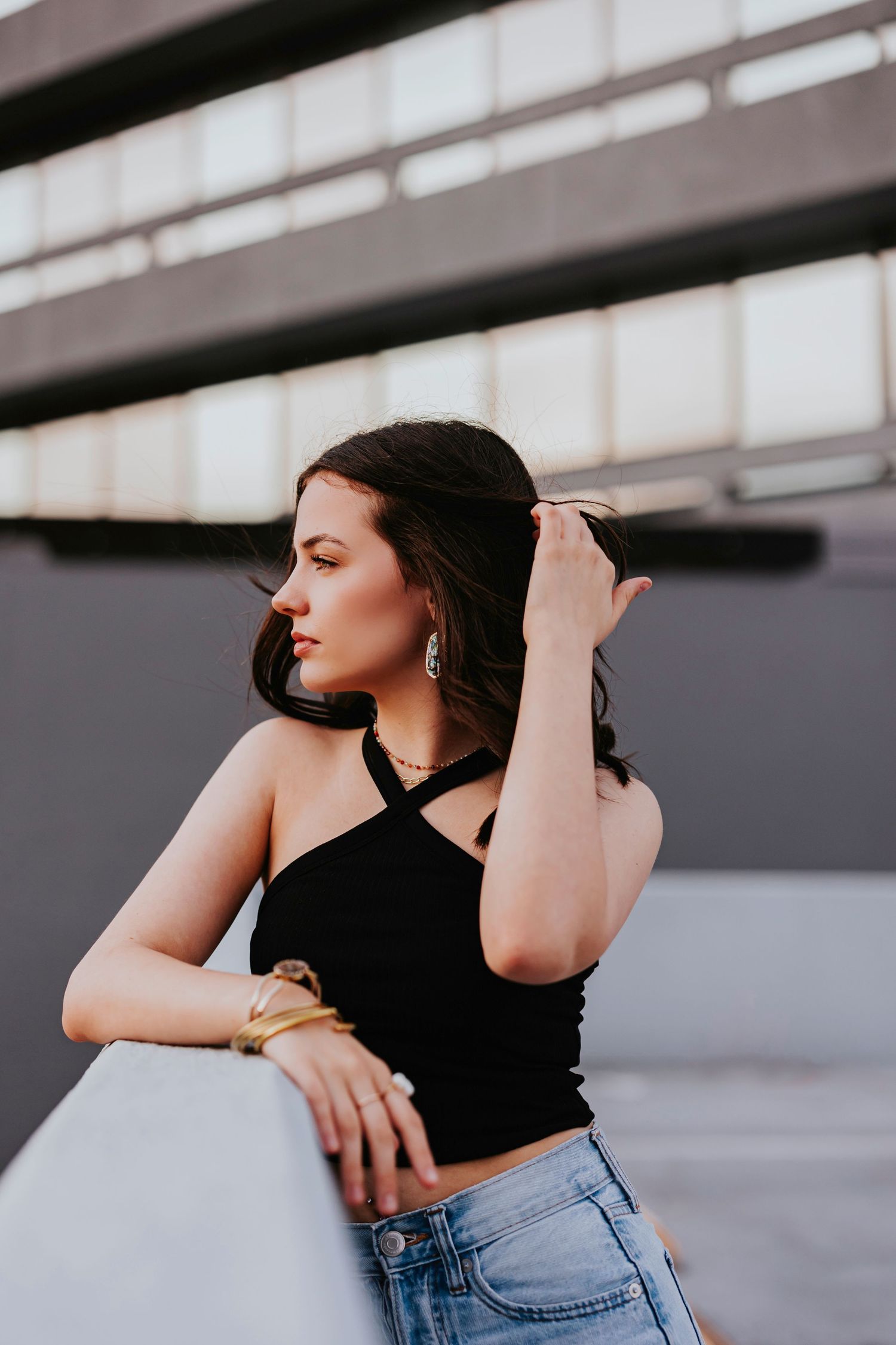Artistic fashion portrait series showing a black crop top and jeans against an industrial backdrop.