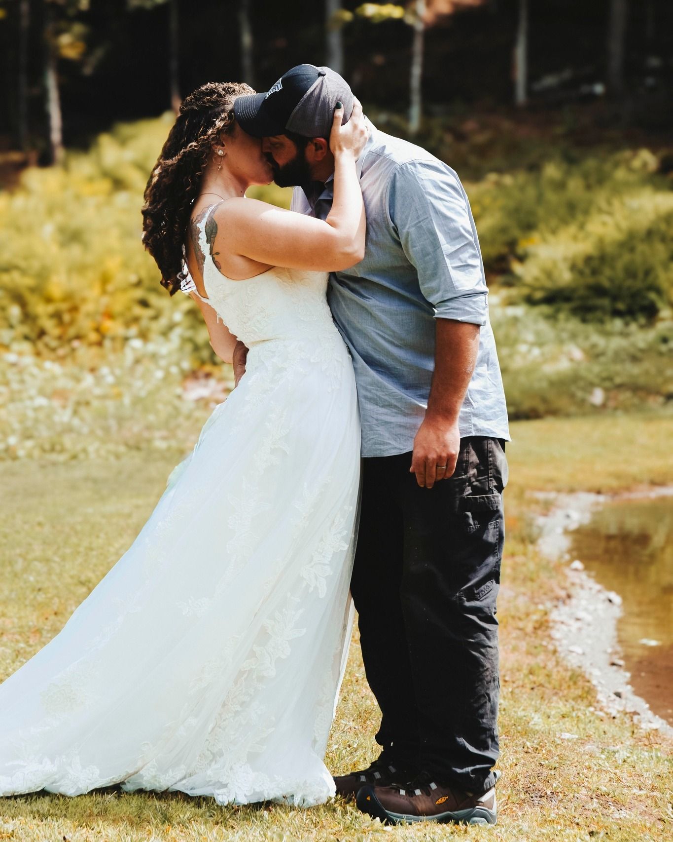 Wedding portrait by Northern Exposure featuring a bride and groom in front of a pond.