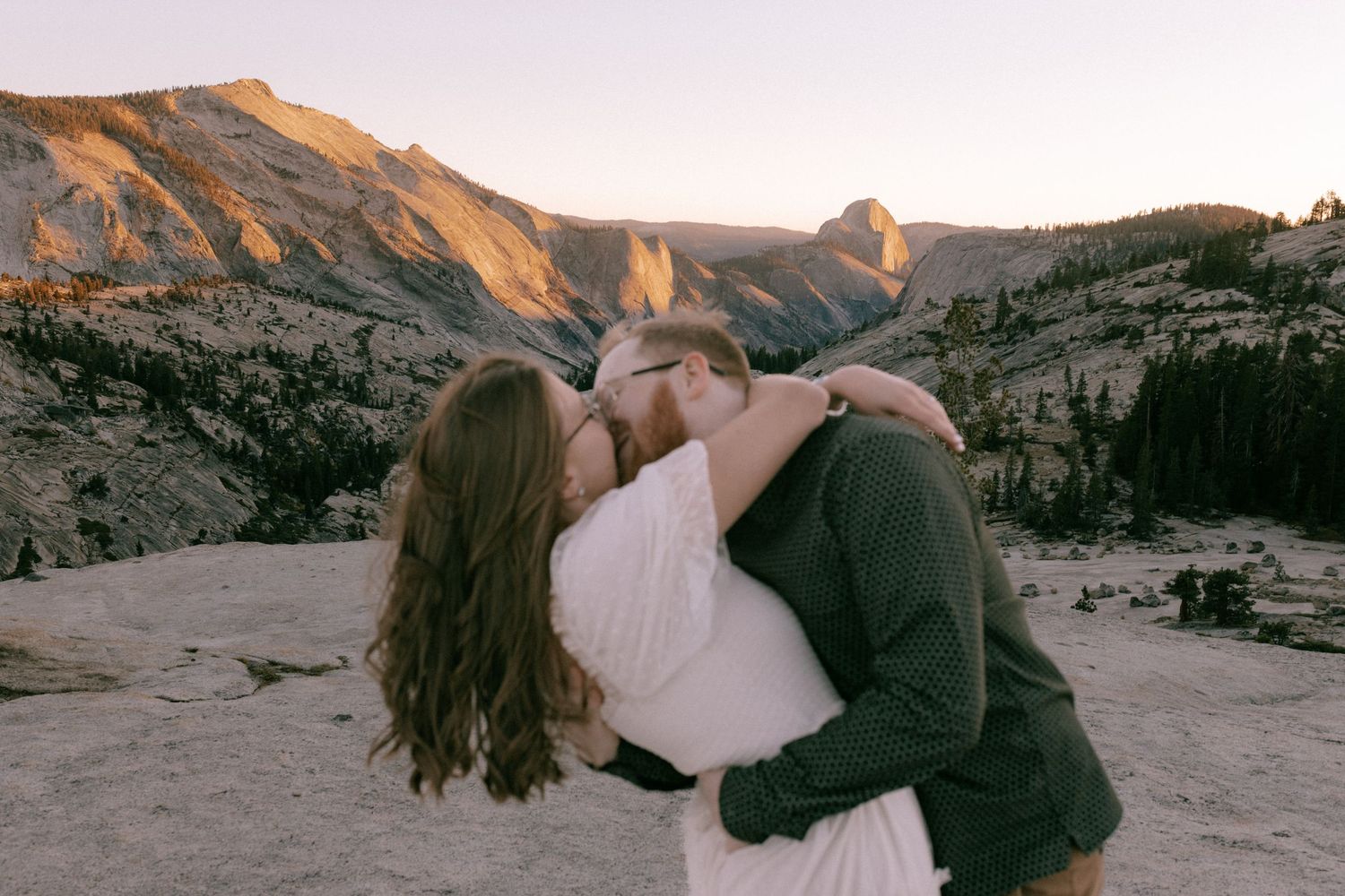A couple embraces in front of scenic desert rock formations during golden hour at Vasquez Rocks Natural Area.