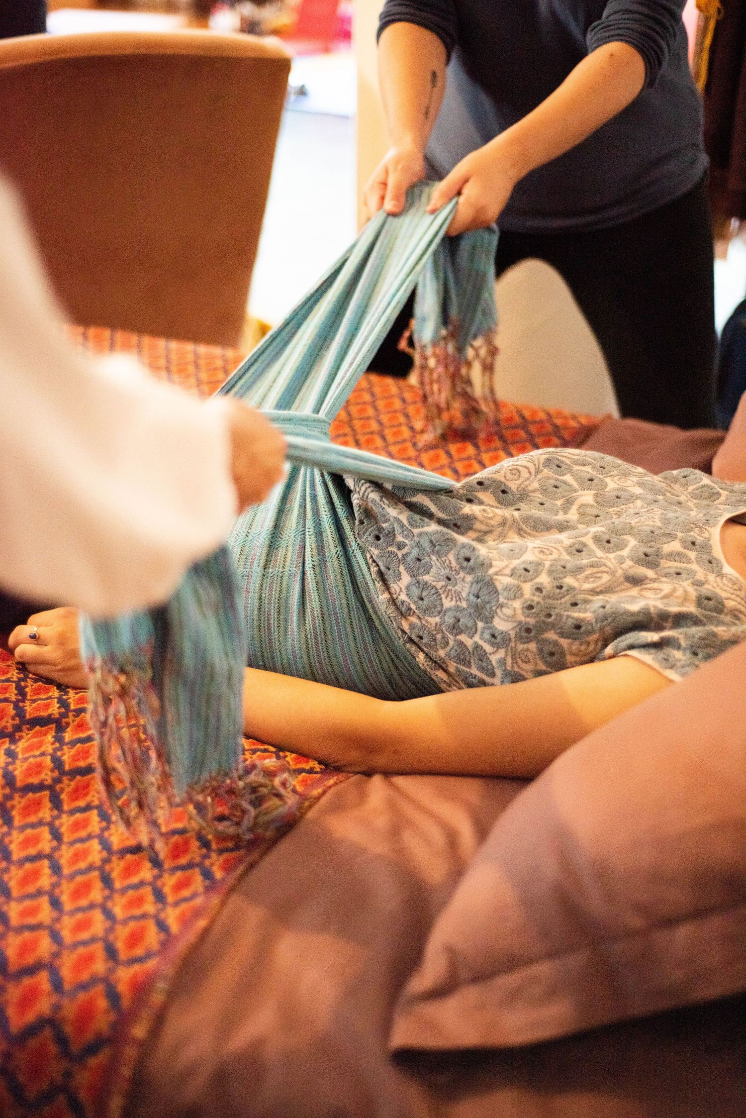 A sequence showing traditional Thai massage therapy techniques being performed on a client lying on a patterned mat.